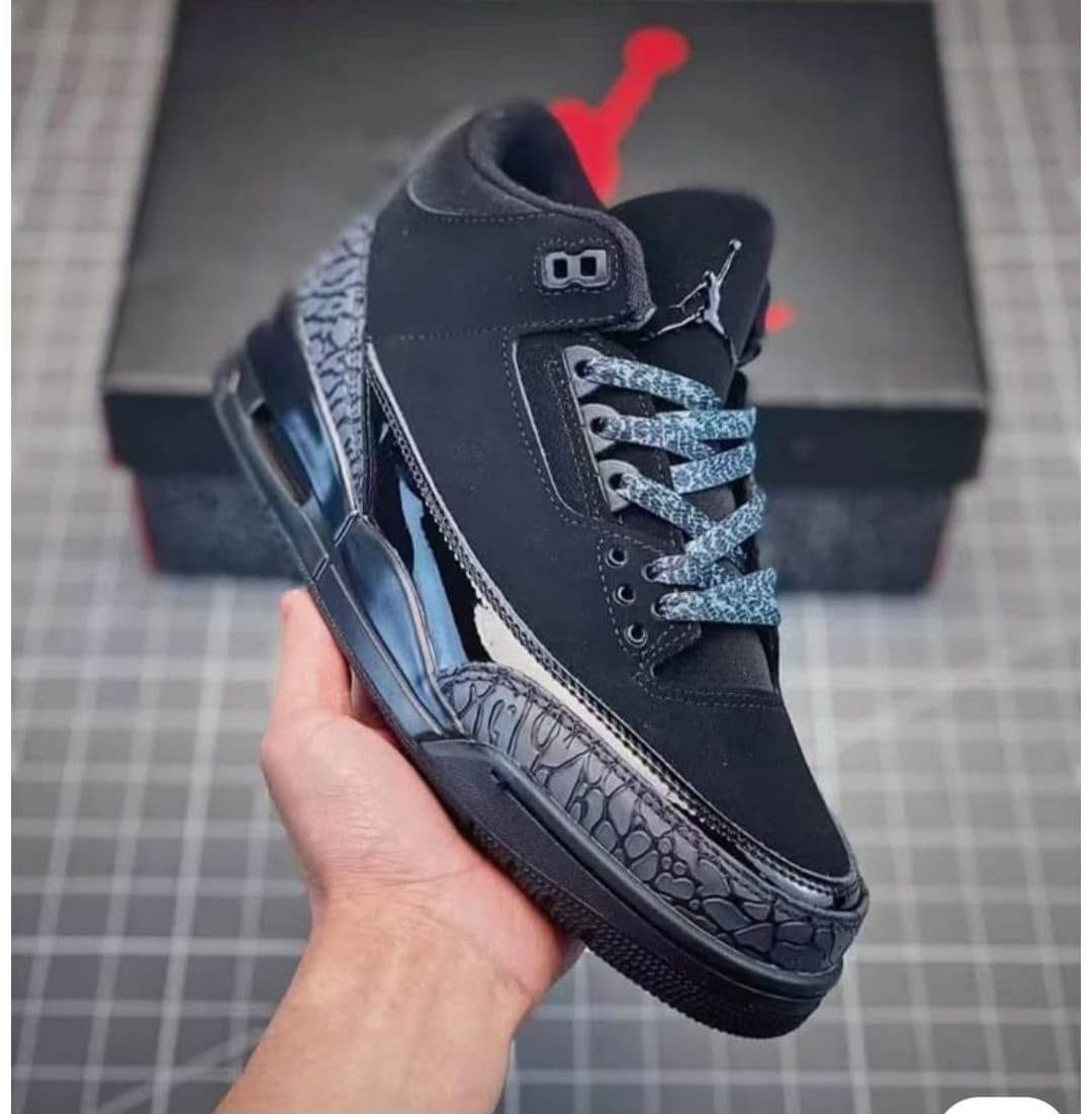 Black sneaker held in hand