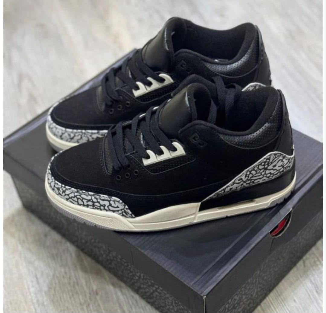 Black sneaker pair in a shoe box