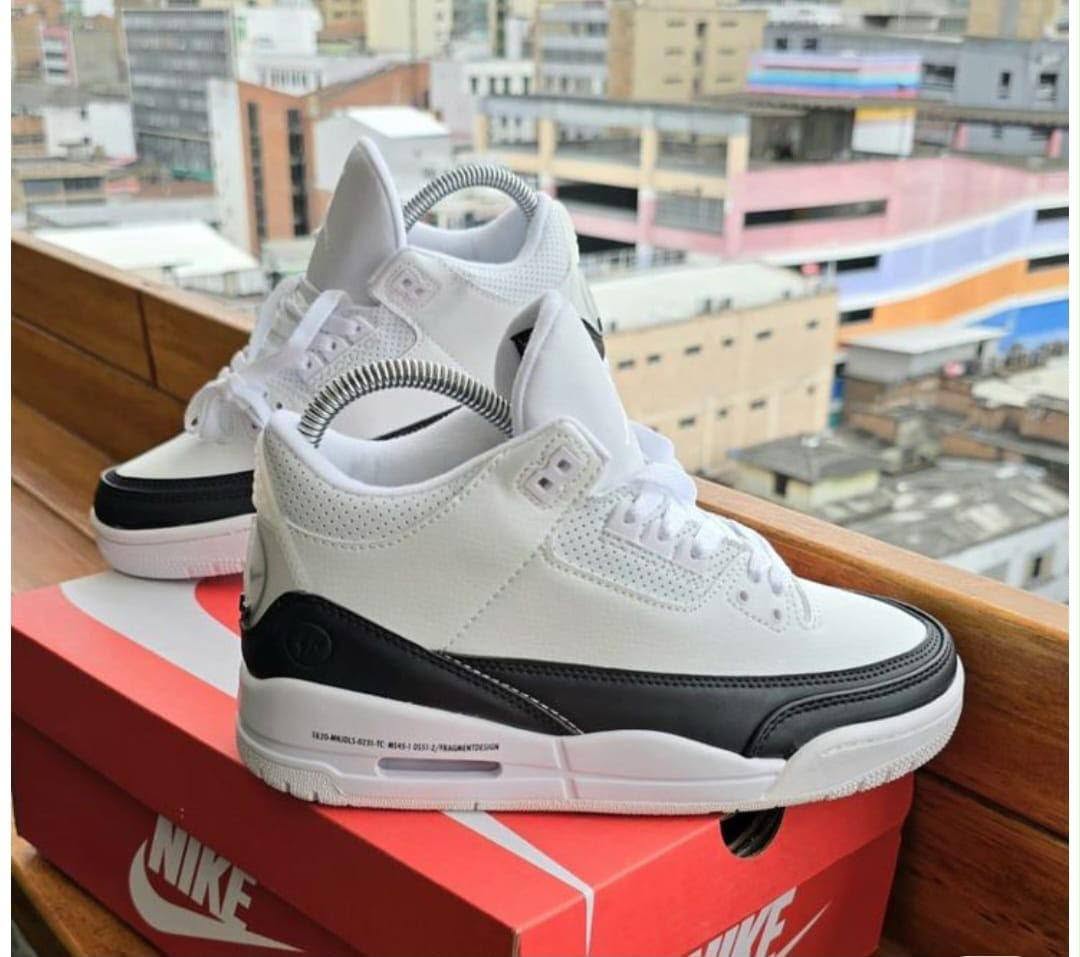 White and black high-top sneakers on a red shoe box